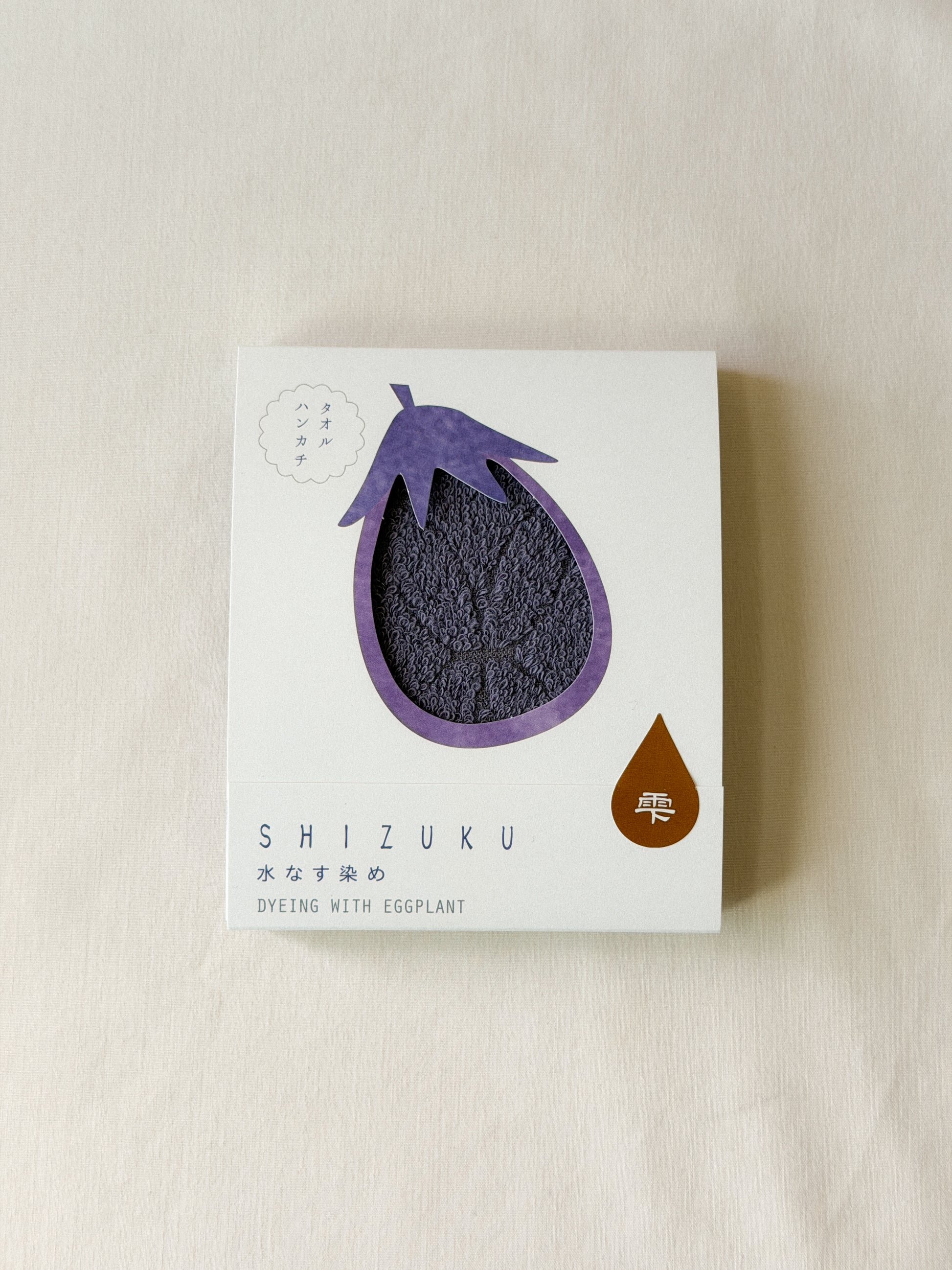 Packaged purple towel with a cut-out of an eggplant