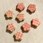 Flower-shaped ceramic magnets with four different checkered design in ivory and pink