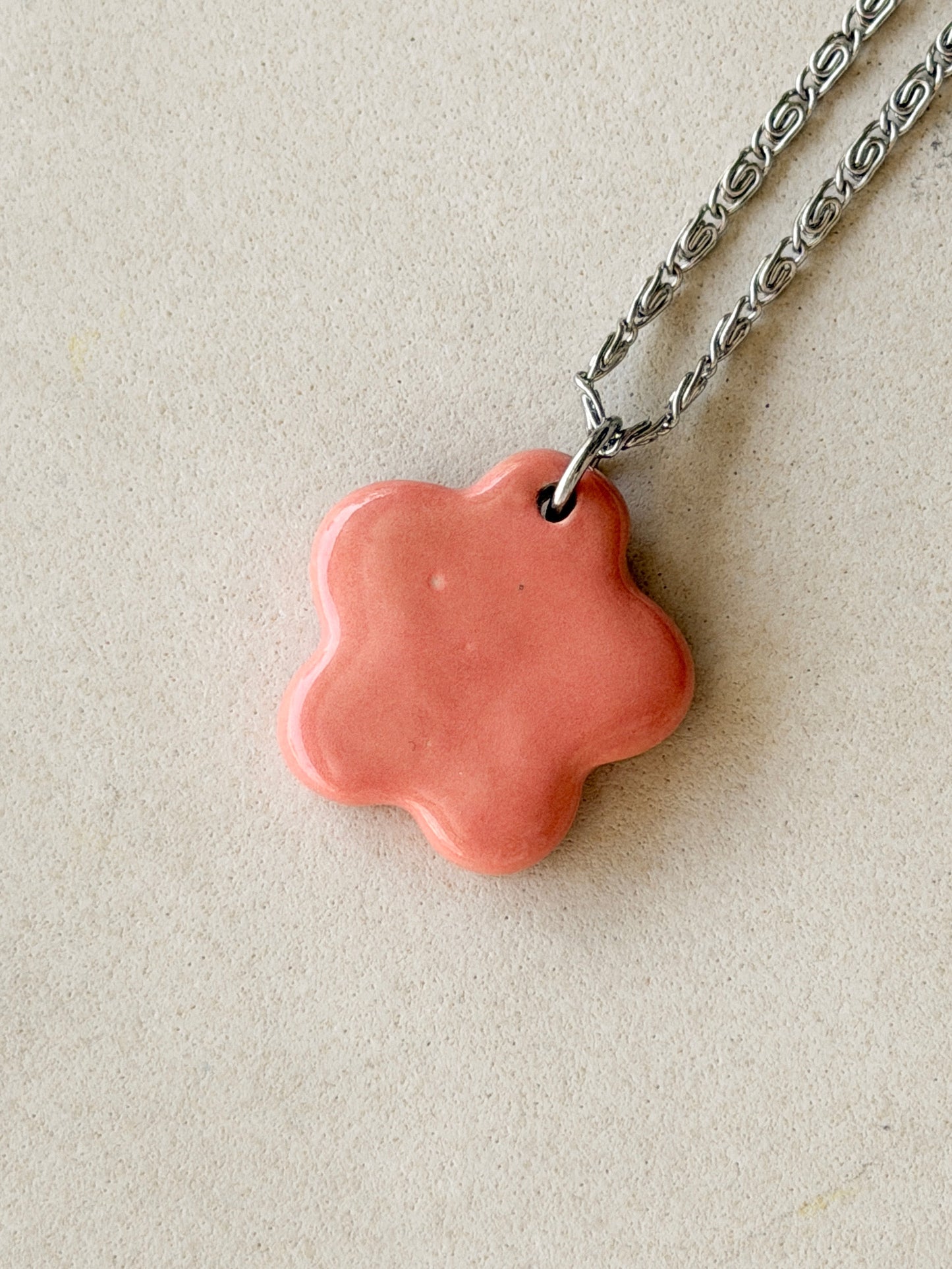 Stainless steel necklace with a glossy floral shaped pink ceramic pendant