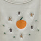 Up-close image of the design of the tank top, showing embroidered tangerine, flowers, and Chinese characters for luck and hand-sewn clusters of beads