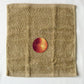 Textured brown towel with an onion illustration in the center on a white background