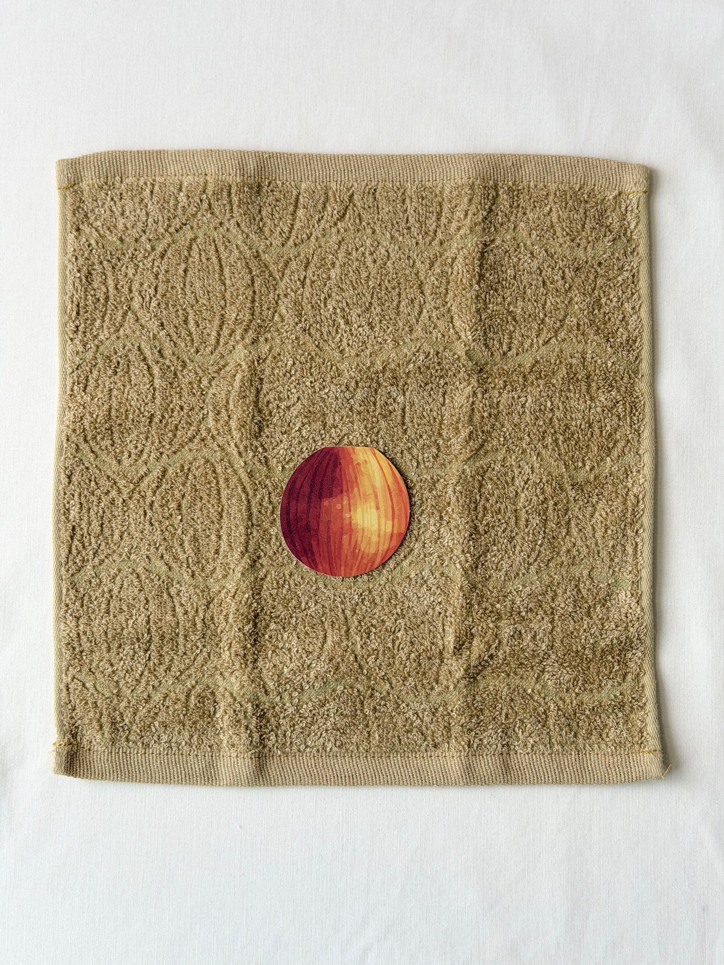 Textured brown towel with an onion illustration in the center on a white background