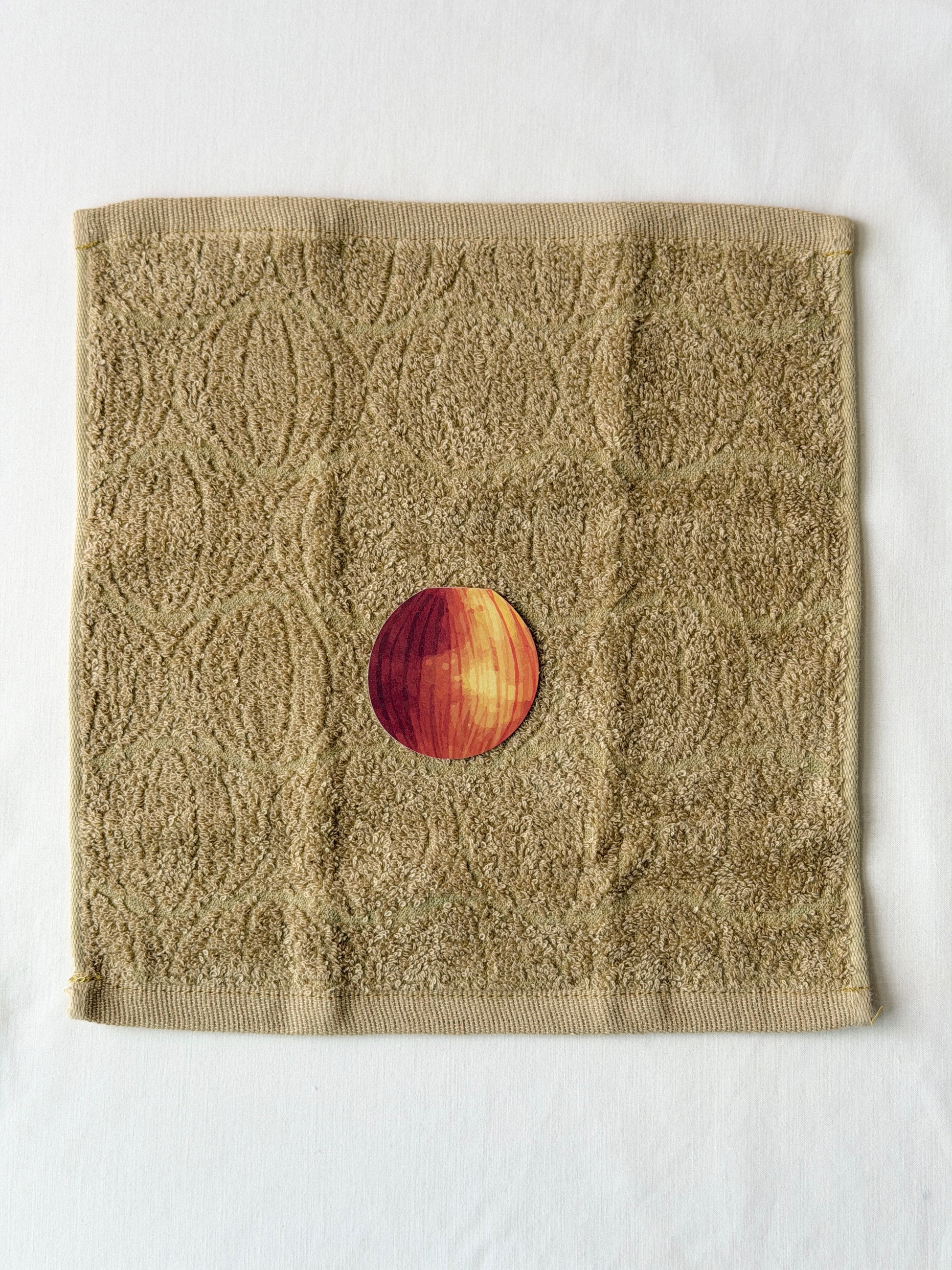 Textured brown towel with an onion illustration in the center on a white background